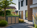 Ecoscape Triple Bin Storage with Planter in Woodgrain and Charcoal in an outdoor setting